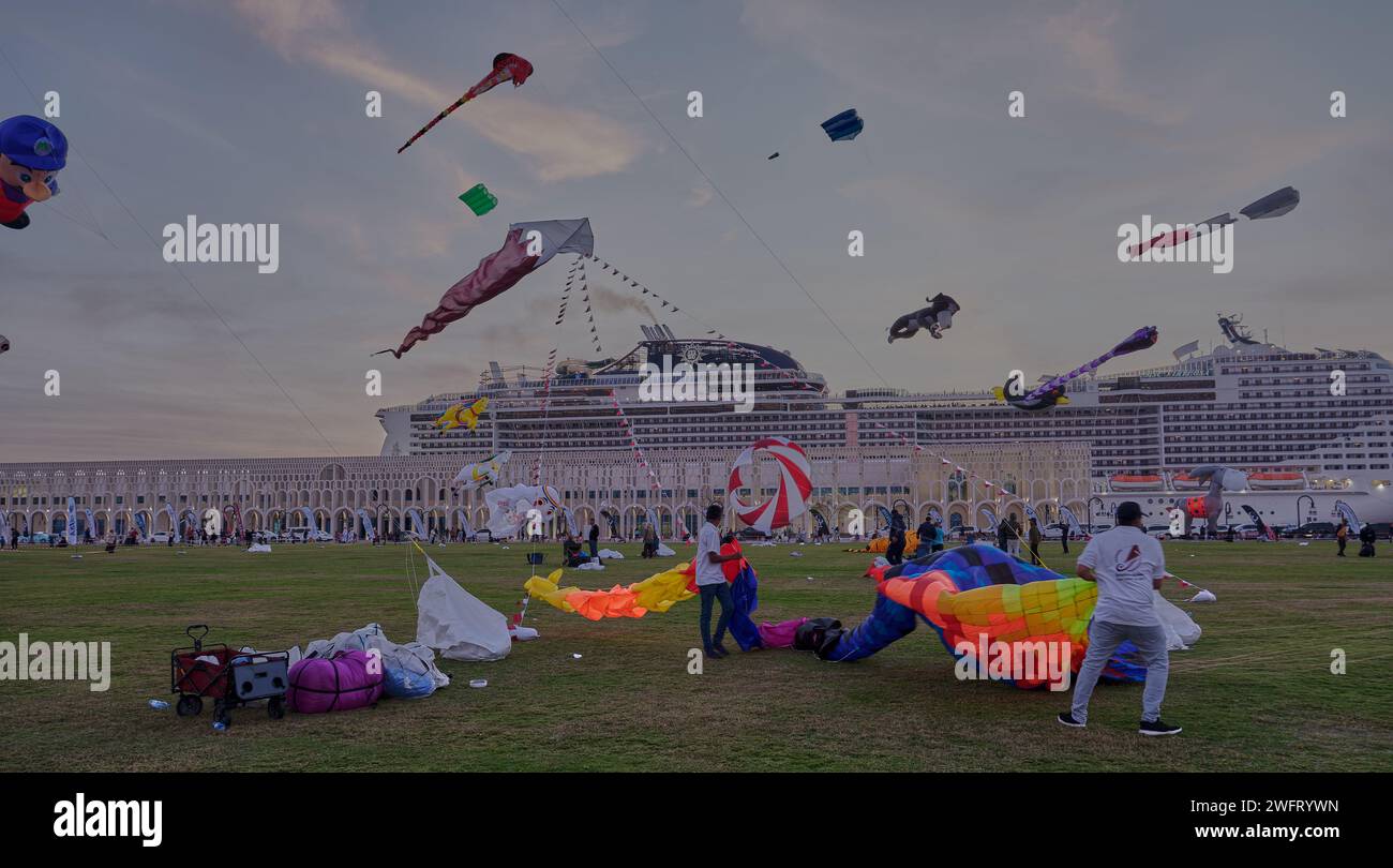 Qatar Kite Festival 2024 dans le vieux port de Doha (district de Mina) coucher du soleil montrant une vitrine spectaculaire de cerfs-volants colorés planant à travers Doha, Skyline Banque D'Images