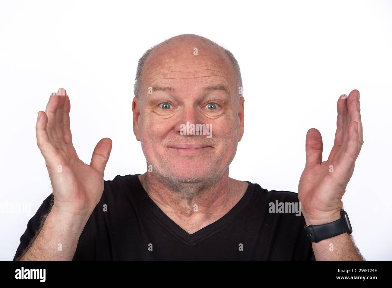 Homme d'âge moyen souriant en T-shirt noir avec les mains levées sur fond blanc - concept Happy Lifestyle Banque D'Images