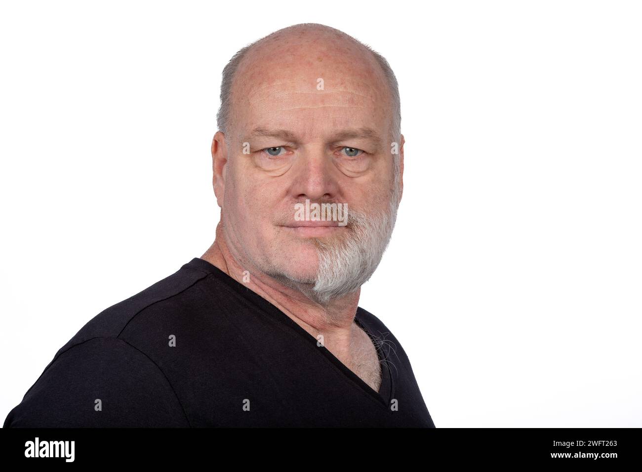 Homme d'âge moyen focalisé avec barbe à moitié rasée dans un élégant T-shirt noir - Portrait confiant sur fond blanc Banque D'Images