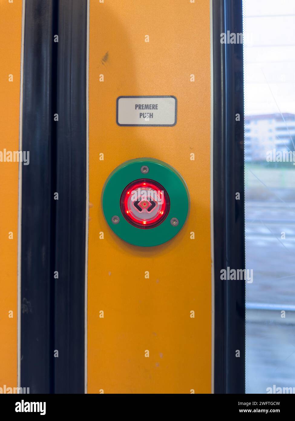 Un détail d'un bouton de sortie coloré et lumineux et des portes, d'un train rapide Malpensa Express, sur le chemin de Milan, Milan, Italie Banque D'Images