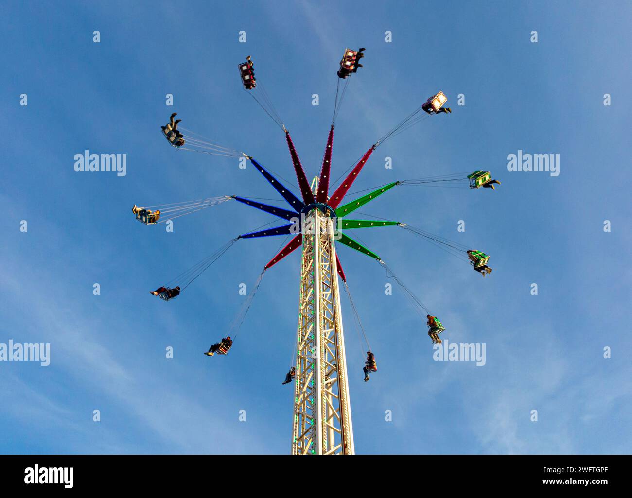 Manège swing carrousel fairground avec ciel bleu derrière opérant dans le centre-ville de Leeds West Yorkshire Angleterre Royaume-Uni. Banque D'Images