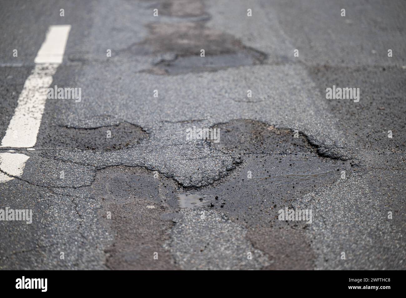 , Alltag, 01.02.2024, Detailaufnahme eines Schlaglochs in einer asphalerten Straße, umgeben von Rissen und beschädigtem Belag. Die Textur des ASPHA Banque D'Images