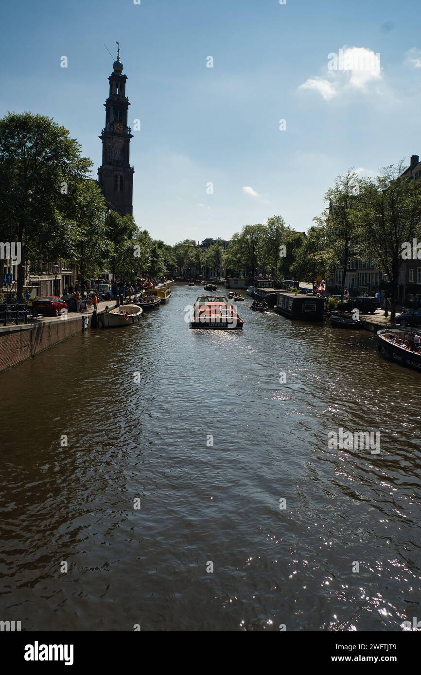 Amsterdam, pays-Bas- juillet 8,2022 : Canal d'Amsterdam avec bateaux de croisière avec maison traditionnelle néerlandaise à Amsterdam, pays-Bas. Paysage et culte Banque D'Images
