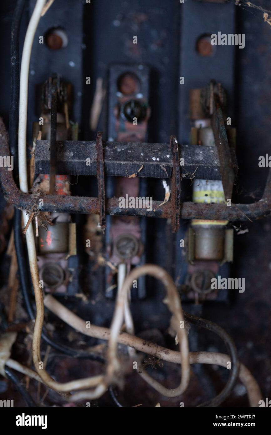 Boîte à fusibles électrique antique en décomposition avec des fils et de la rouille. Banque D'Images