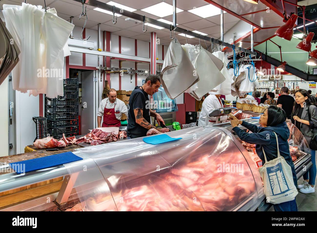 Les gens achètent de la viande dans une boucherie à Florence Mercato Centrale, un marché animé et populaire de produits frais à Florence, en Italie Banque D'Images