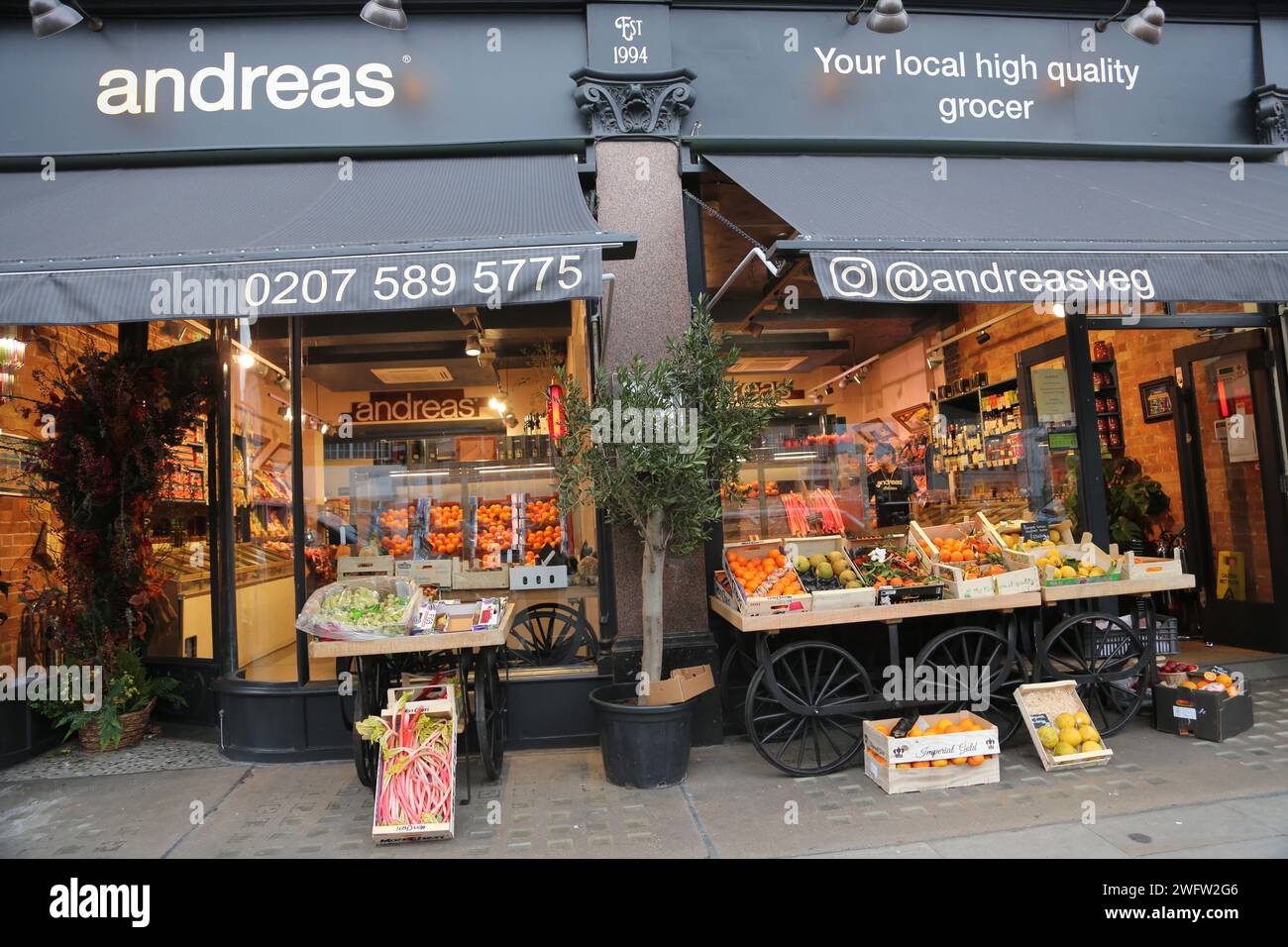 Stands devant Andreas Greengrocers vendant figues, rhubarbe, raisins, oranges et tomates cale Street Chelsea Londres Angleterre Banque D'Images