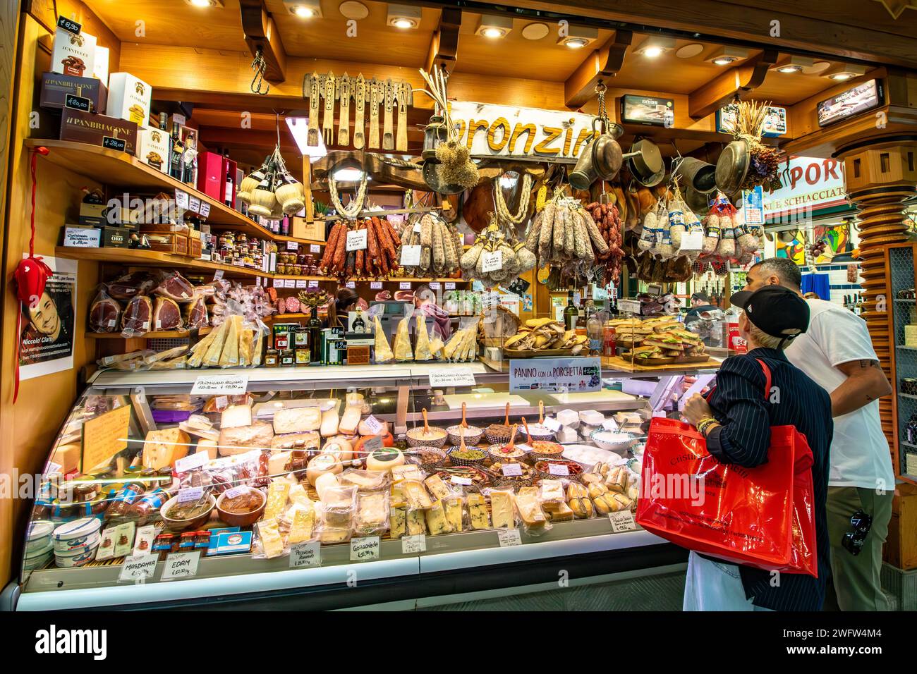 Les gens font des courses dans une épicerie fine pour la charcuterie et le fromage à Florence Mercato Centrale, un marché populaire de produits frais et de produits frais à Florence, en Italie Banque D'Images