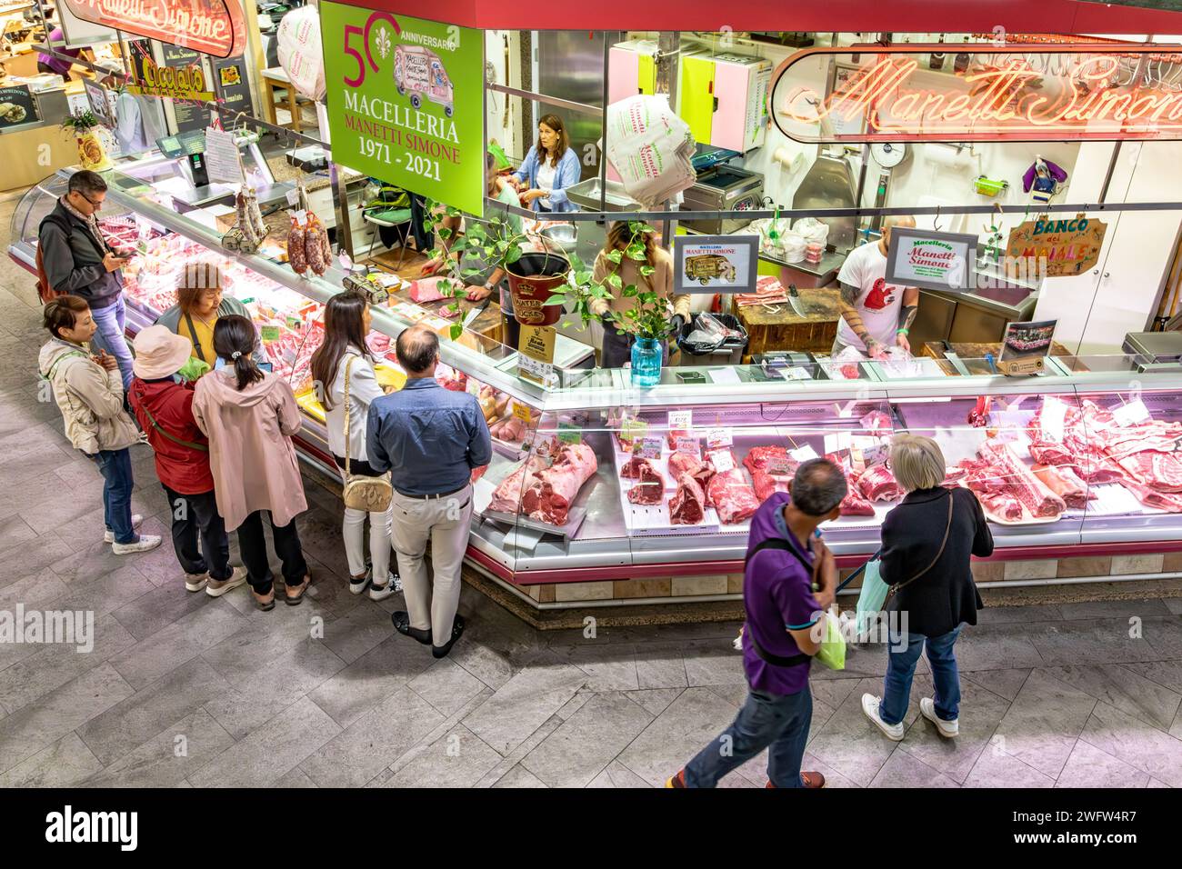 Les gens magasinent de la viande dans un comptoir de viande de boucherie à Florence Mercato Centrale, un marché animé et populaire de produits frais et de fruits et légumes frais à Florence en Italie Banque D'Images