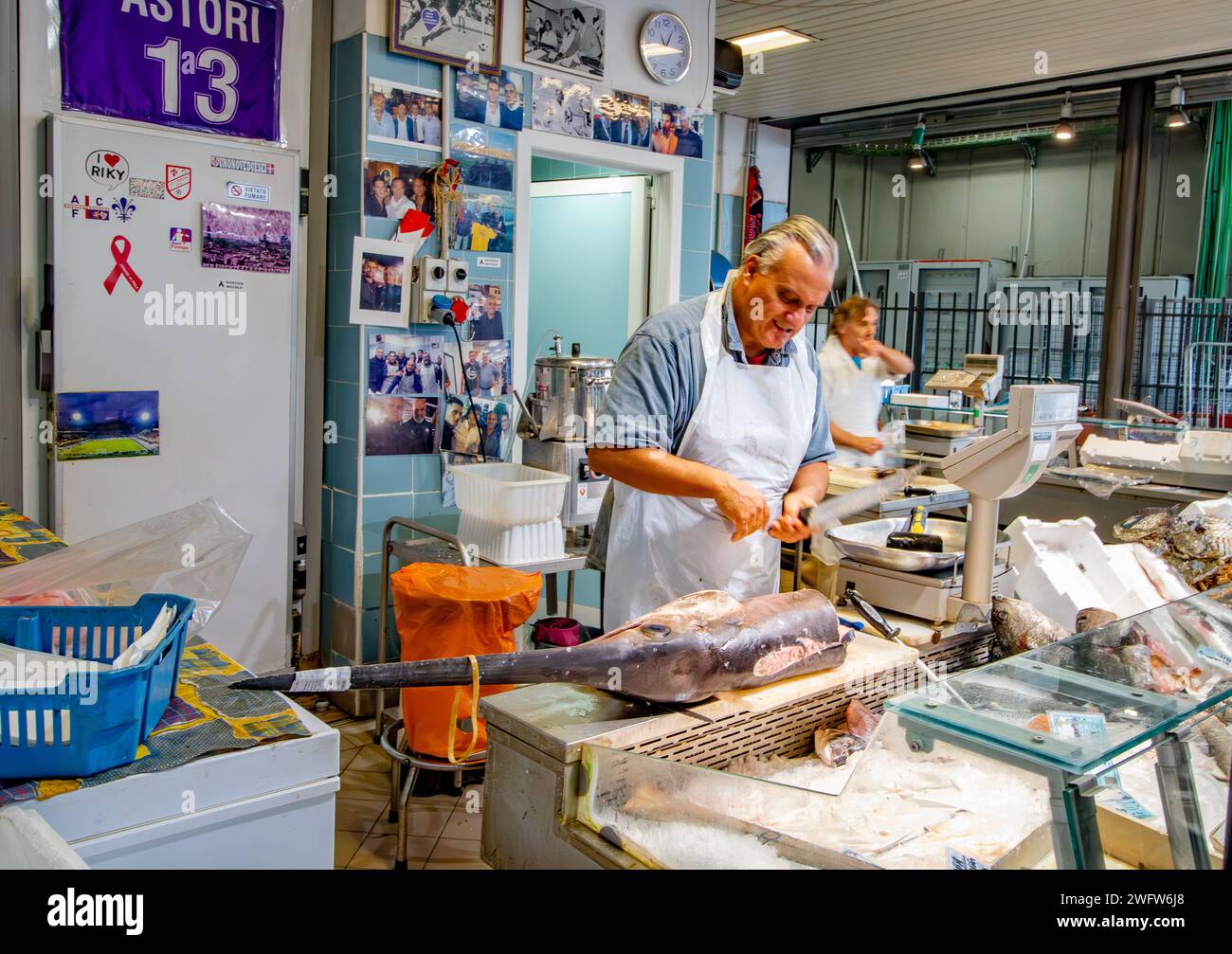 Un poissonnier préparant un espadon à Florence Mercato Centrale , un marché animé et populaire d'aliments frais et de produits de Florence, Italie Banque D'Images