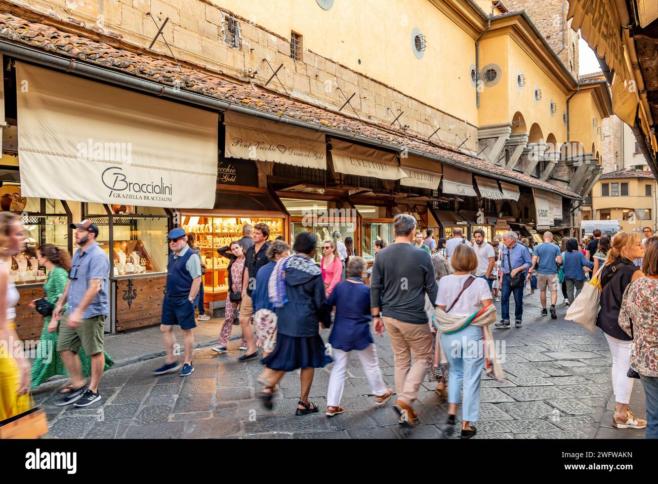 Foules de gens marchant sur le pont Ponte Vecchio parcourant les nombreuses bijouteries qui bordent les deux côtés du pont à Florence, en Italie Banque D'Images