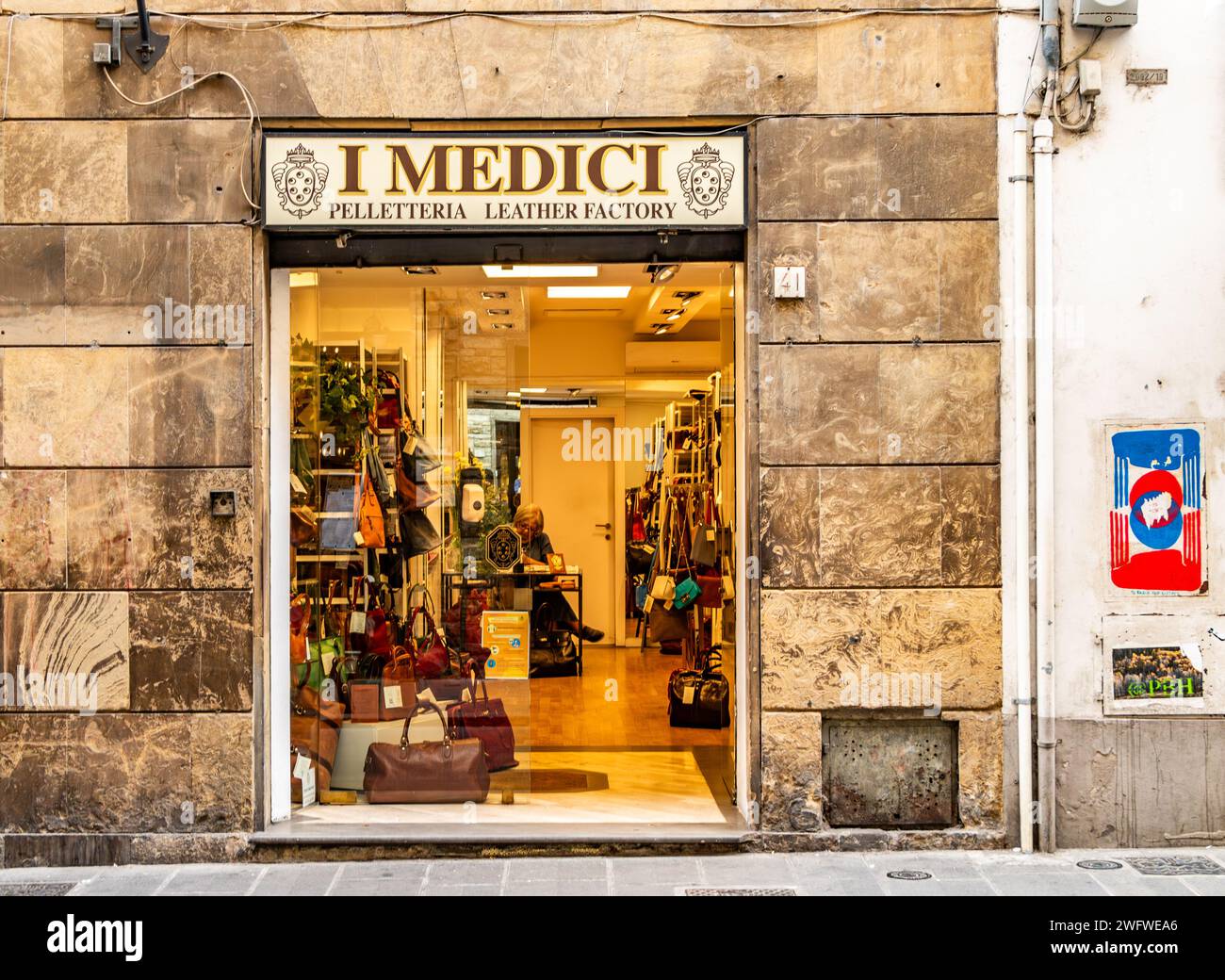 Une femme assise à un bureau à l'intérieur I Medici un magasin de maroquinerie sur la via de' Guicciardini dans le quartier Oltrano de Florence en Italie Banque D'Images