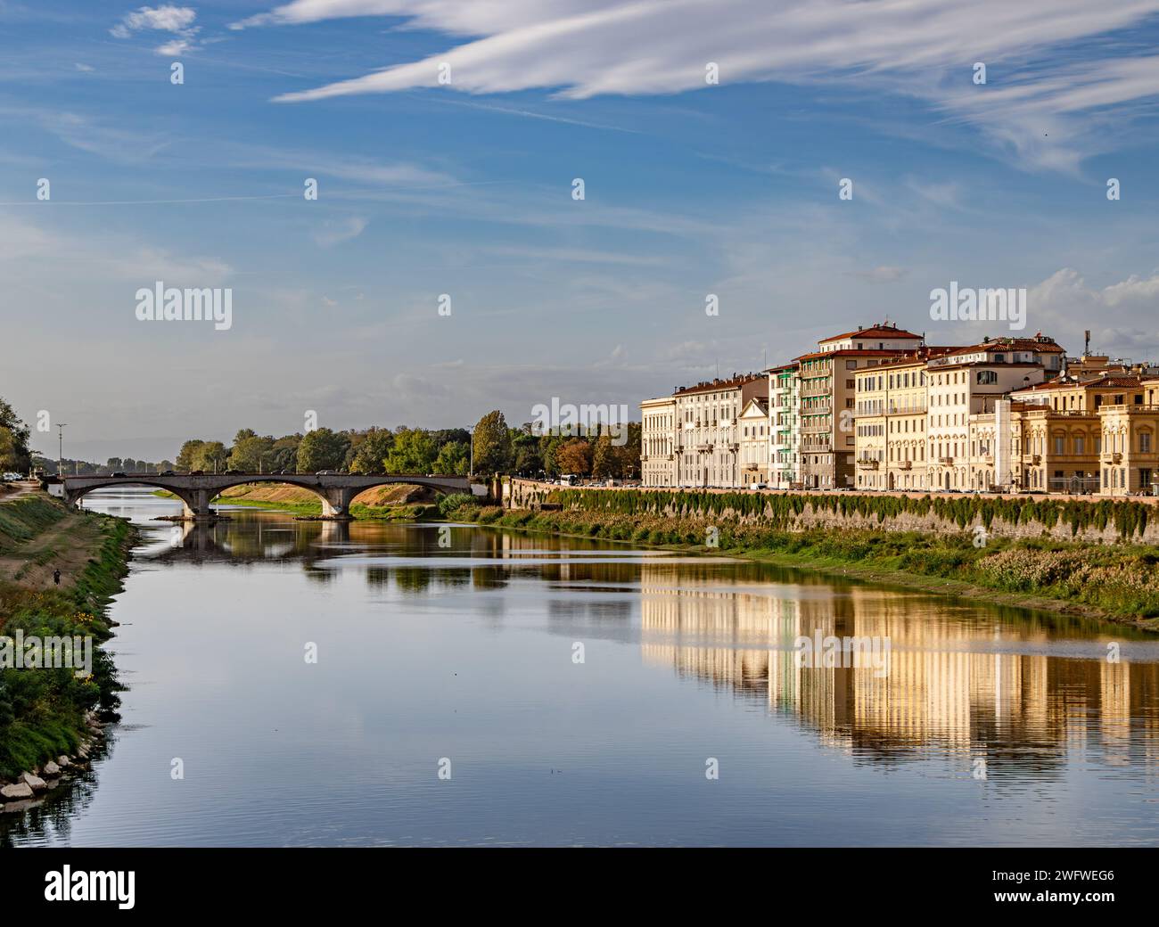 Bâtiments reflétant sur la rivière Arno dans le soleil de fin d'après-midi Florence, Italie Banque D'Images