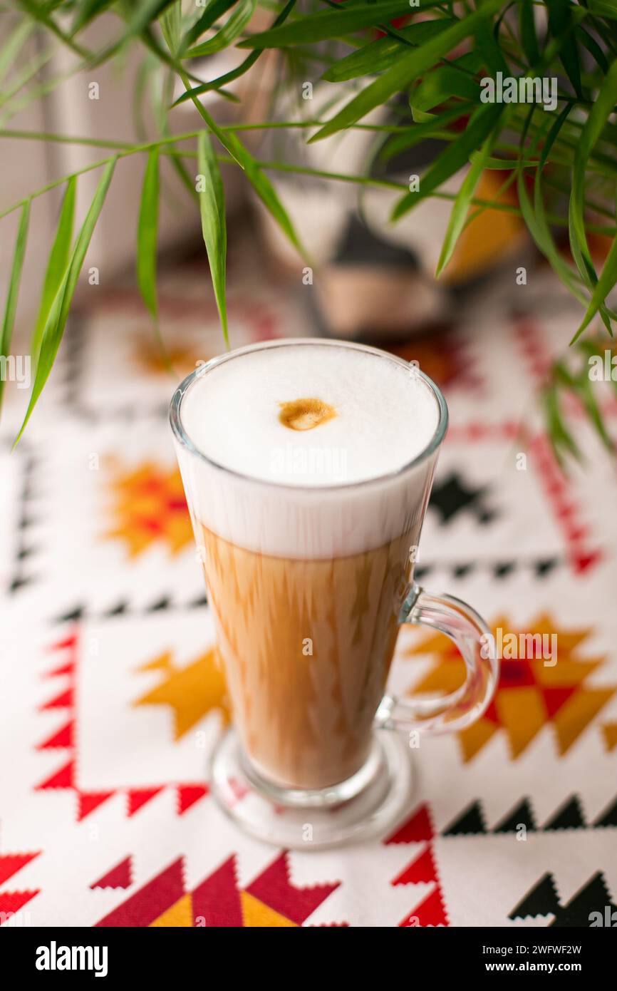 Tasse de café latte cappuccino et feuilles vertes. gros plan Banque D'Images