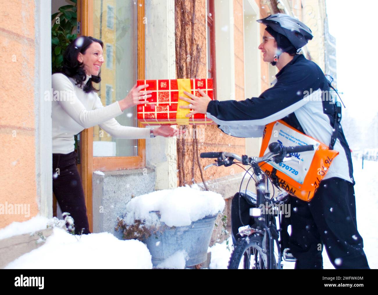 Un transporteur à vélo livre un colis, Munich, Allemagne Banque D'Images