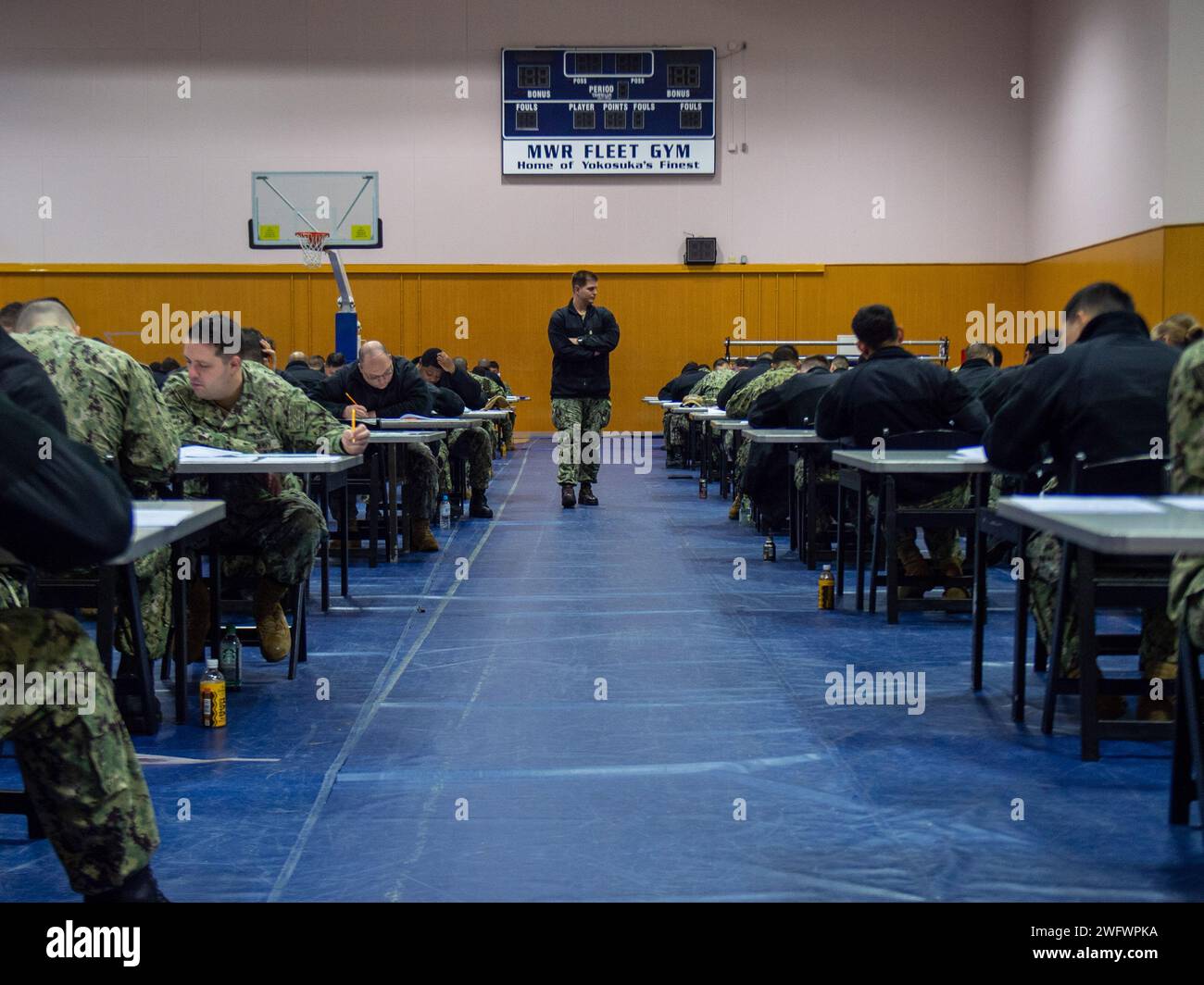 Brian Graham, technicien en chef en électronique de l’aviation, centre, de Tacoma, Washington, surveille l’examen d’avancement du E-7 à l’échelle de la marine pour les marins affectés au seul porte-avions déployé à l’avant de l’US Navy, USS Ronald Reagan (CVN 76), au moral, Welfare, and Recreation Fleet Gym alors qu’il était commandant au port, Fleet Activities Yokosuka, janvier 18. Ronald Reagan, le navire amiral du Carrier Strike Group 5, fournit une force prête au combat qui protège et défend les États-Unis, et soutient les alliances, les partenariats et les intérêts maritimes collectifs dans la région Indo-Pacifique. Banque D'Images