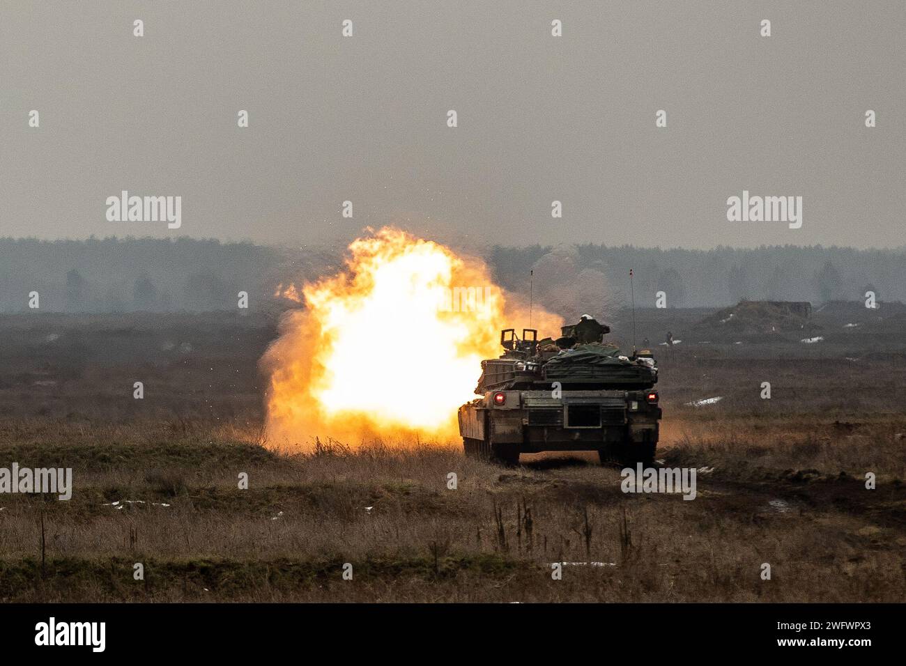 Soldats de l'armée américaine de la compagnie Alpha, 2e bataillon, 69e régiment blindé, équipe de combat de la 2e brigade blindée, 3e division d'infanterie, tirs d'un char M1A2 Abrams lors d'un exercice de tir réel dans la zone d'entraînement de Bemowo Piskie, Pologne, le 31 janvier 2024. La mission de la 3e Division d’infanterie en Europe est de s’engager dans des entraînements et des exercices multinationaux à travers le continent, en travaillant aux côtés des alliés de l’OTAN et des partenaires de sécurité régionaux pour fournir des forces crédibles au combat au V corps, le corps avancé déployé des États-Unis en Europe. Banque D'Images