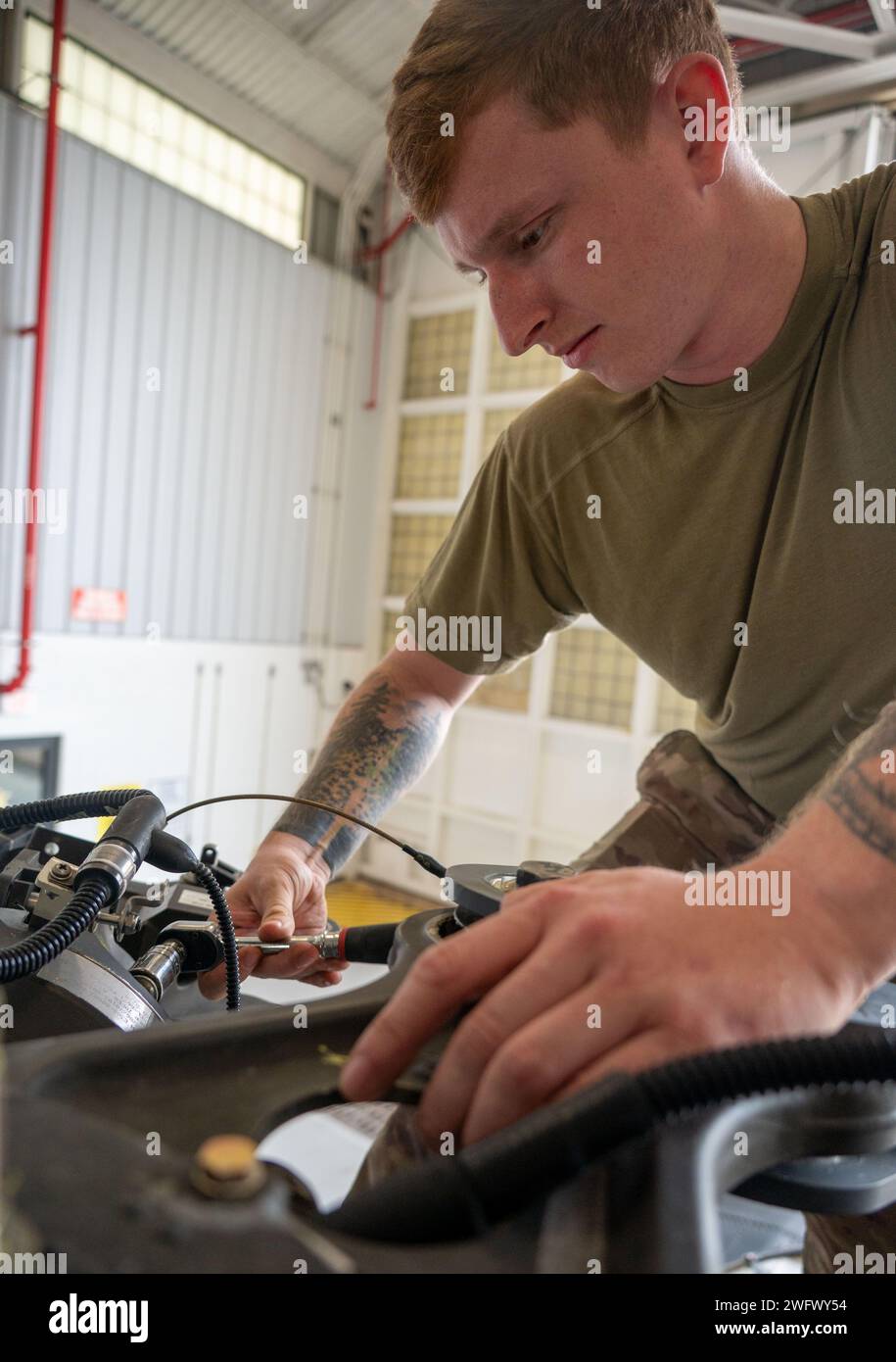 Le sergent d'état-major chance Tabor, technicien en avionique du 920e Escadron de maintenance d'aéronefs, enlève un axe de la tête du rotor principal d'un hélicoptère HH-60G Pave Hawk à l'intérieur d'un hangar de maintenance à la Patrick Space Force base, Floride, le 3 janvier 2024. Ces broches remplaceront celles corrodées sur un autre Pave Hawk. Les axes sont retirés de ce Pave Hawk parce qu'il est prévu de le retirer au 309th Aerospace Maintenance and Regeneration Group en Arizona plus tard ce mois-ci, marquant le début de la conversion de l'aile au nouveau HH-60W Pave Hawk. Banque D'Images