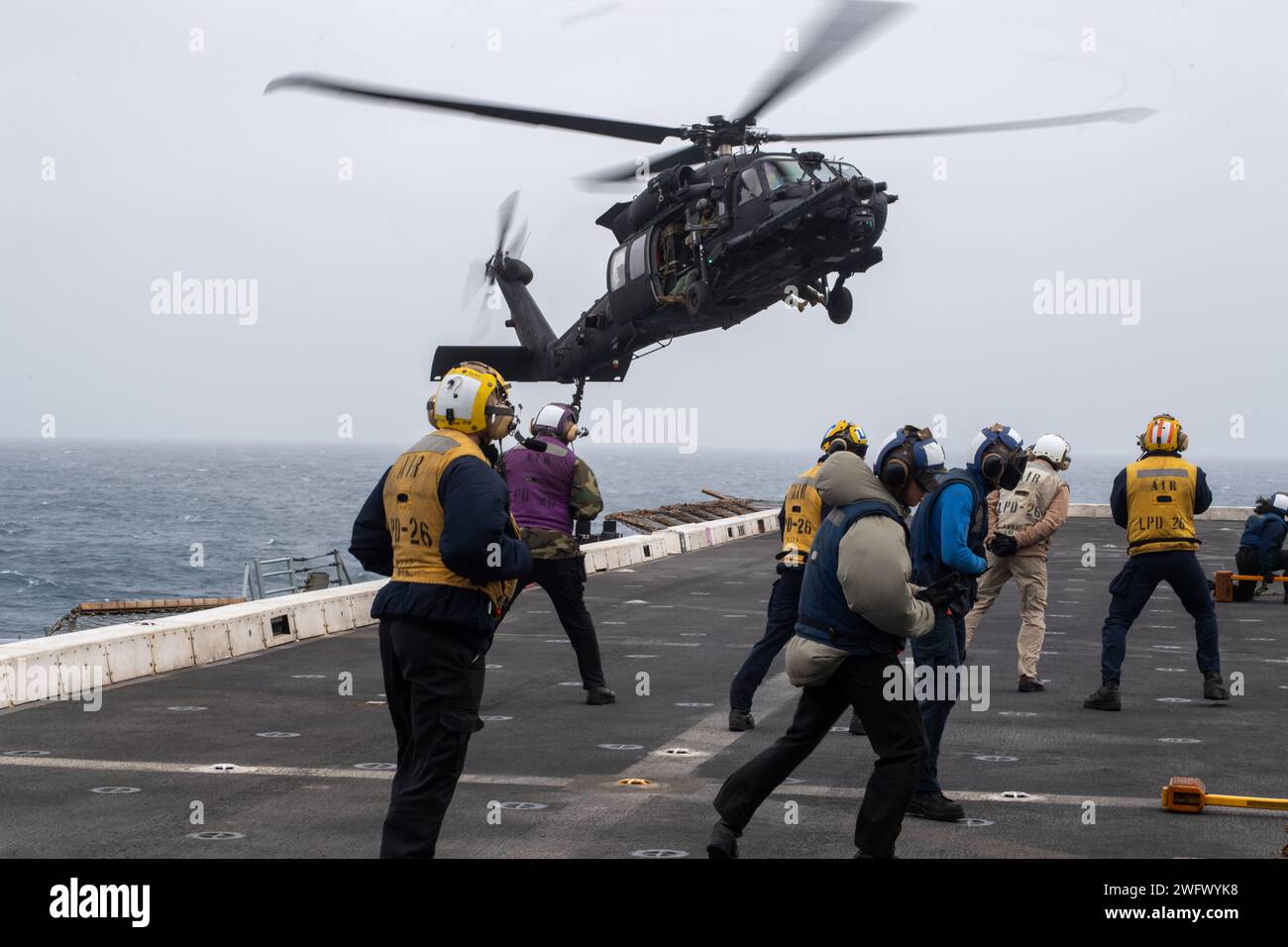 Les marins à bord du navire amphibie USS John P. Murtha (LPD 26) observent un hélicoptère MH-60M Blackhawk, affecté au 160th Special Operations Aviation Regiment (Airborne), atterrir sur le pont d'envol lors de l'opération POLAR DAGGER, le 2 septembre 2023. Les navires de transport amphibies comme John P. Murtha ont de nombreuses capacités uniques qui en font des plates-formes idéales pour soutenir les forces d'opérations spéciales, telles que la capacité d'embarquer des hélicoptères de la force conjointe, de lancer et de récupérer des engins de combat Naval Special Warfare, et de maintenir une connaissance de tous les domaines grâce à des capteurs avancés. Opérations NOBLES Banque D'Images