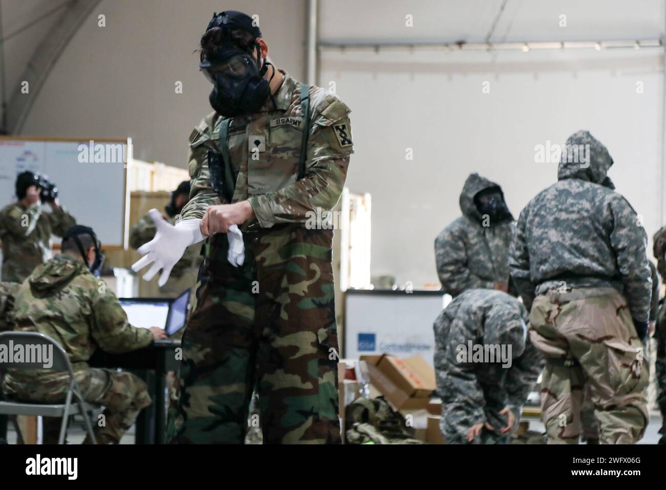 Hunter Horn, un opérateur de transport motorisé affecté à la 414th Transportation Company, qui fait partie du fournisseur de la Force opérationnelle de la 3rd Division Sustainment Brigade, met des vêtements de protection lors d'un exercice d'attaque chimique à Karliki, Pologne, le 19 janvier 2024. Le Bataillon de soutien au maintien de la 87e Division a organisé l’événement de formation pour s’assurer que les soldats sont prêts à intervenir rapidement pour se protéger et poursuivre leurs opérations, même dans un environnement de menace chimique, biologique, radiologique et nucléaire. Ces soldats sont déployés en Europe pour assurer les alliés et soutenir le train multinational Banque D'Images