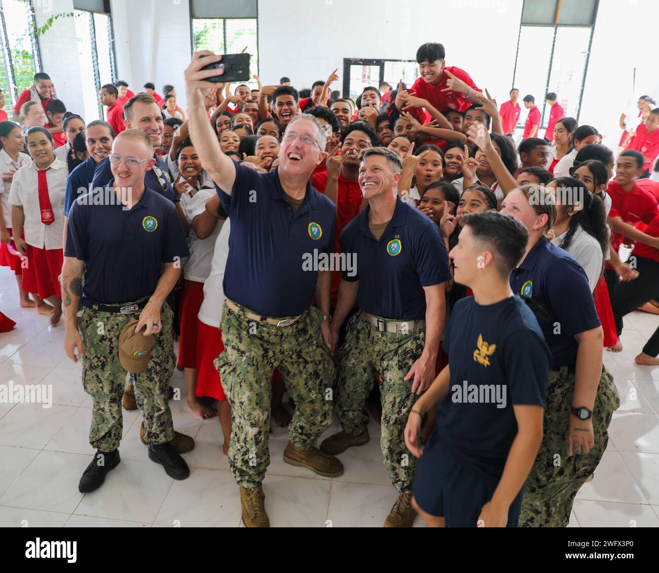 Le capitaine Brian Quin, commandant, Pacific Partnership 2024-1, au centre, et le capitaine Jeffrey Feinberg, commandant du navire-hôpital USNS Mercy (T-AH 19), au centre droit, prennent un selfie avec des marins et des étudiants de la marine américaine lors d'une campagne de sensibilisation du pays hôte, même à la Xavier High School de Chuuk, États fédérés de Micronésie, dans le cadre du Partenariat du Pacifique 2024-1 janvier 12, 2024. Maintenant dans sa 19e édition, le Partenariat du Pacifique est la plus grande mission multinationale annuelle d’assistance humanitaire et de préparation aux catastrophes menée dans l’Indo-Pacifique. Banque D'Images