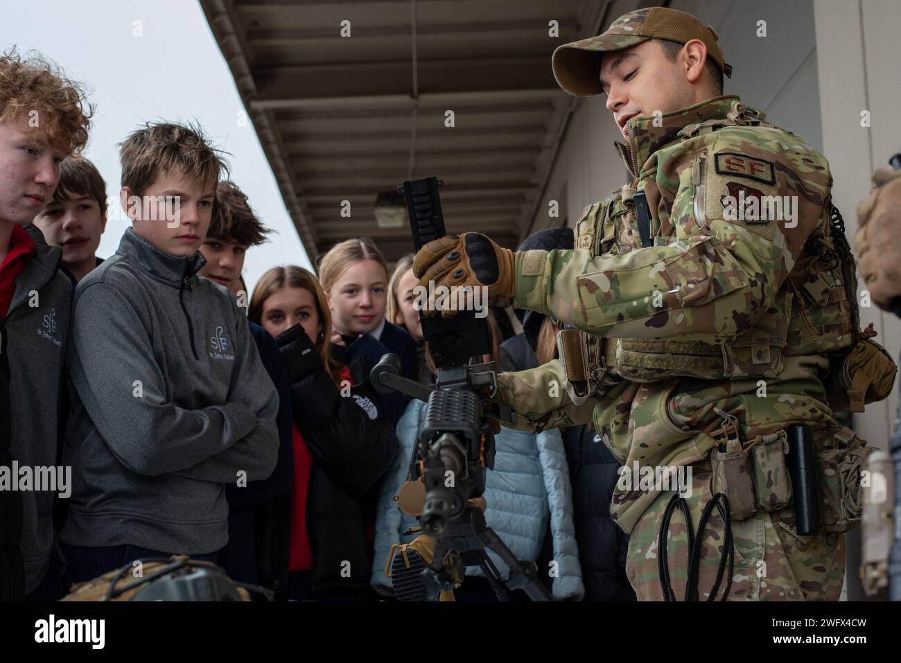 Tech. Le Sgt Reymundo Coronado-Catillo (à droite), 142e Escadron des forces de sécurité, présente les diverses armes et outils que les défenseurs utilisent pendant leur service aux élèves du collège de St. John Fisher School lors d'une visite de la base aérienne de la Garde nationale de Portland, Portland, Oregon, le 10 janvier 2023. La visite publique a donné aux étudiants de la région de Portland l'occasion de voir de près la mission de la 142e Escadre et de se familiariser avec les divers emplois qui englobent la mission de l'Escadre. Banque D'Images