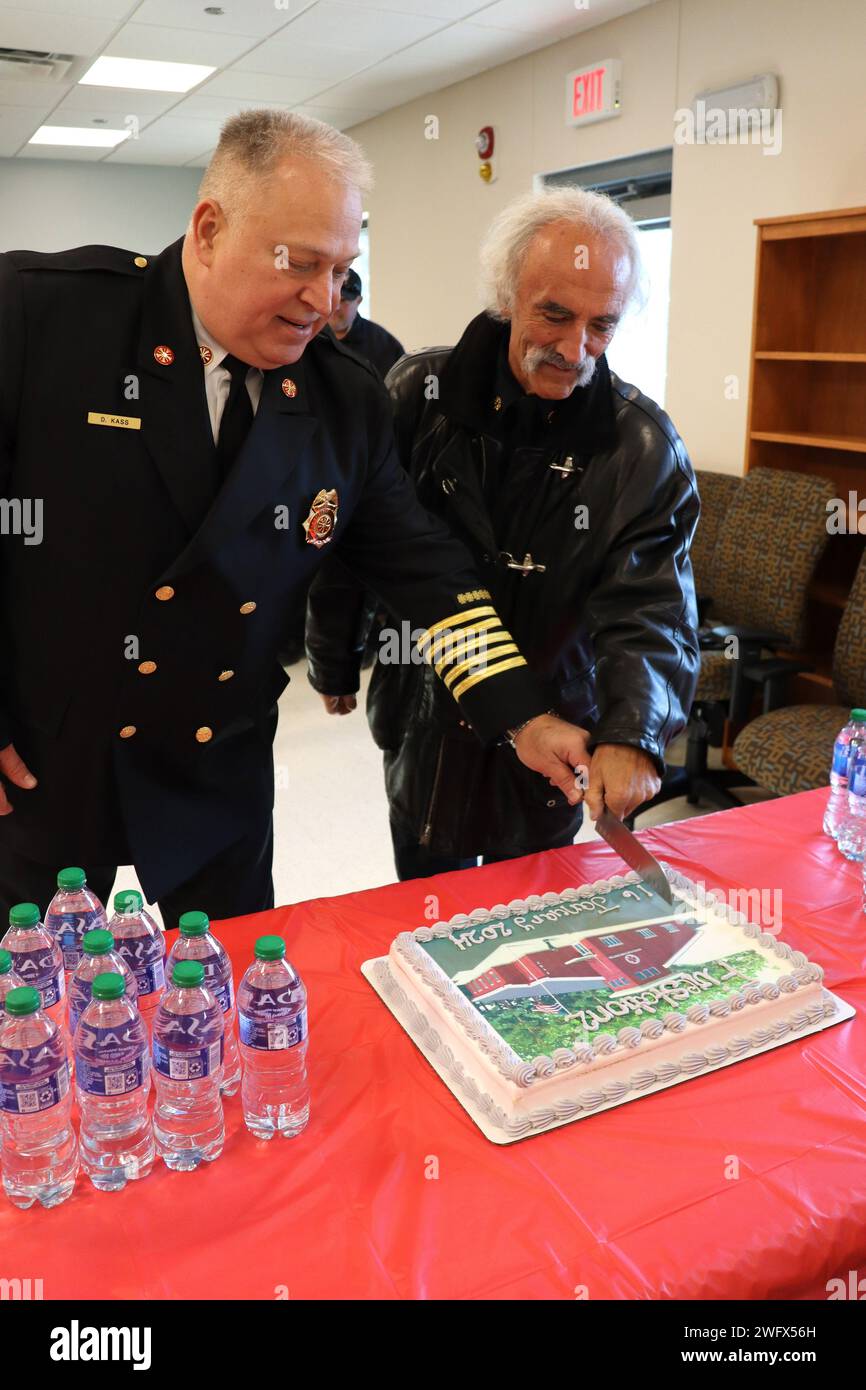 Le chef des pompiers de fort Johnson, David J. Kass (à gauche), et l'ancien chef des pompiers Michael Kuk, ont coupé le gâteau pour célébrer l'ouverture de la caserne de pompiers de North fort. Banque D'Images