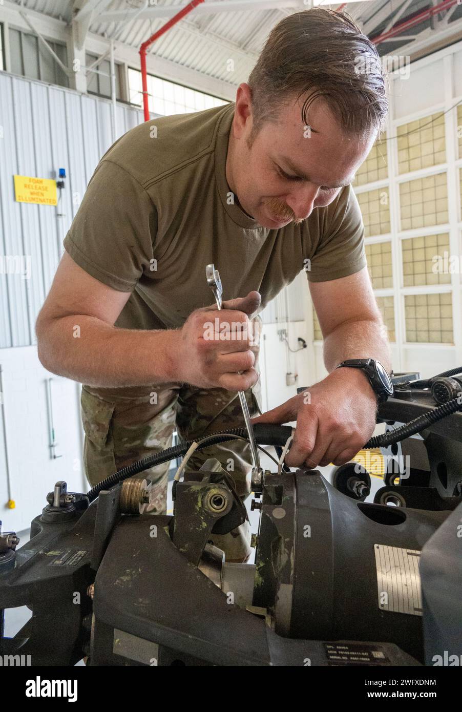 Tech. Le sergent Jeremy Ellison, chef d'équipage du 920e Escadron de maintenance d'aéronefs, enlève un axe de la tête du rotor principal d'un hélicoptère HH-60G Pave Hawk à l'intérieur d'un hangar de maintenance à la Patrick Space Force base, Floride, le 3 janvier 2024. Ces broches remplaceront celles corrodées sur un autre Pave Hawk. Les axes sont retirés de ce Pave Hawk parce qu'il est prévu de le retirer au 309th Aerospace Maintenance and Regeneration Group en Arizona plus tard ce mois-ci, marquant le début de la conversion de l'aile au nouveau HH-60W Pave Hawk. Banque D'Images