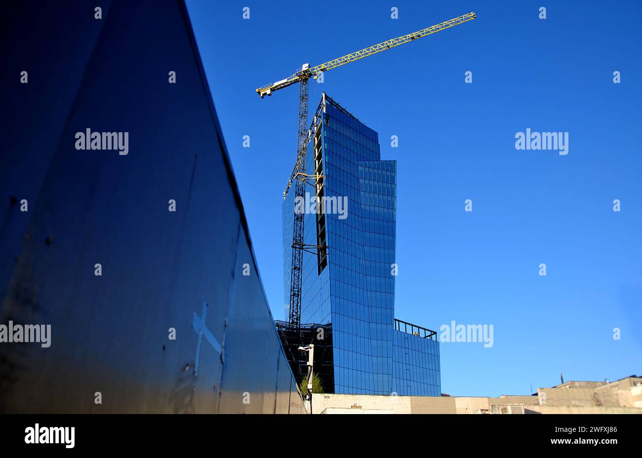 Vilnius (Lituanie) - gratte-ciel en verre moderne en construction. Angle de tir inhabituel. Ciel dégagé, reflets dans les fenêtres Banque D'Images