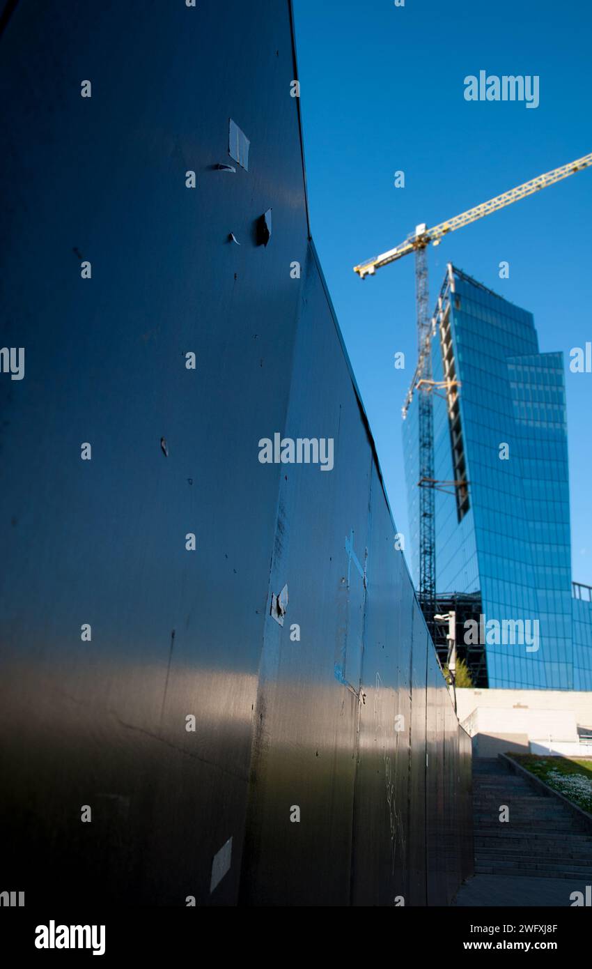 Vilnius (Lituanie) - gratte-ciel en verre moderne en construction. Angle de tir inhabituel. Ciel dégagé, reflets dans les fenêtres Banque D'Images