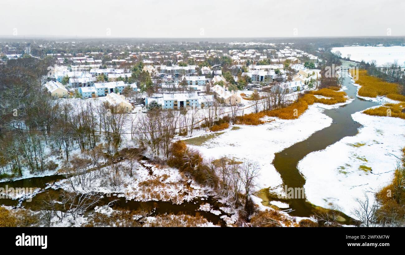 Vue aérienne rurale d'hiver du village de campagne à la rivière couverte de neige Banque D'Images