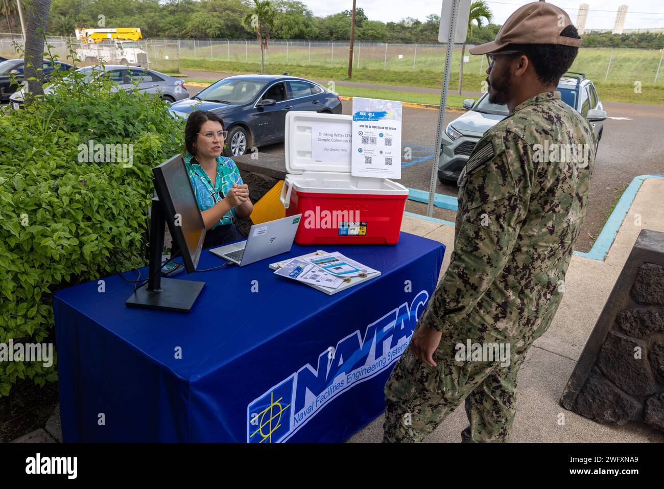 PEARL CITY, Hawaii – Un officier de liaison communautaire du Naval Facilities Engineering Command Hawaii, à gauche, partage des informations sur le programme de surveillance à long terme de l’eau potable de la Marine avec un marin lors du minimart de Pearl City Peninsula Navy Exchange à Pearl City, Hawaii, le 11 janvier 2024. La Marine accueille le kiosque mensuel à divers endroits pour tenir le public informé sur le programme et sur la façon de lire les résultats sur l'eau potable sur le site Web joint base Pearl Harbor-Hickam Safe Waters. Banque D'Images