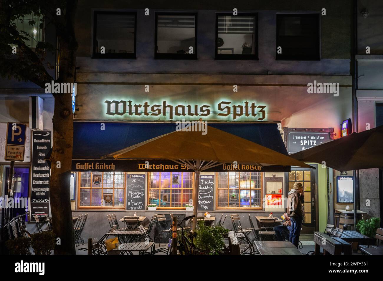 Photo d'un Wirsthaus à Cologne la nuit en automne. Cette image capture l'extérieur de 'Wirtshaus Spitz', une taverne allemande traditionnelle située à Co Banque D'Images