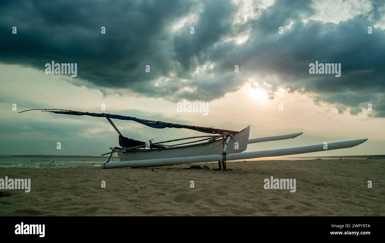 Bateau Fisihing avec mer et plage dans le fond de coucher de soleil Banque D'Images