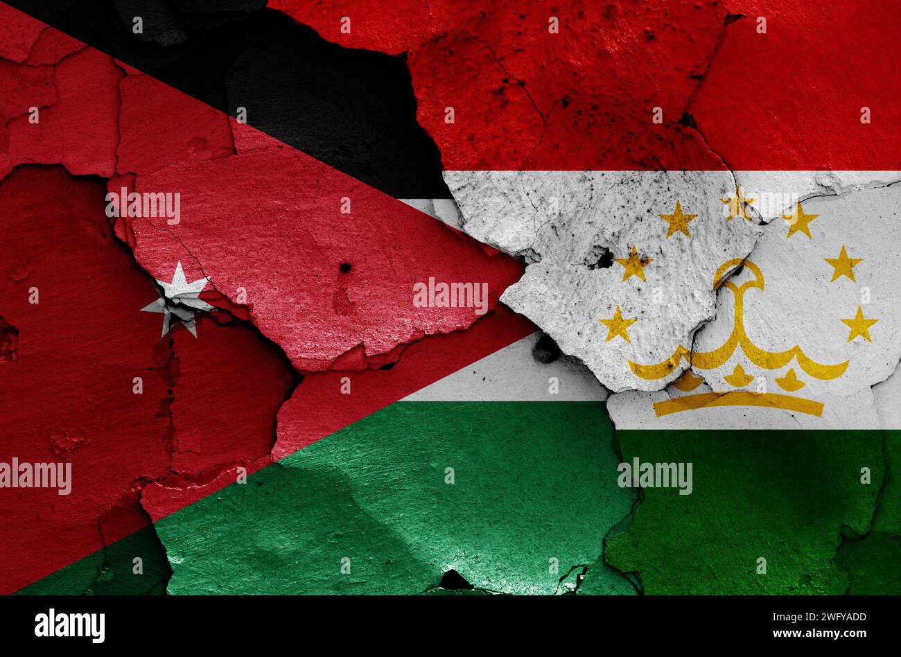 Drapeaux de Jordanie et du Tadjikistan peints sur mur fissuré Banque D'Images