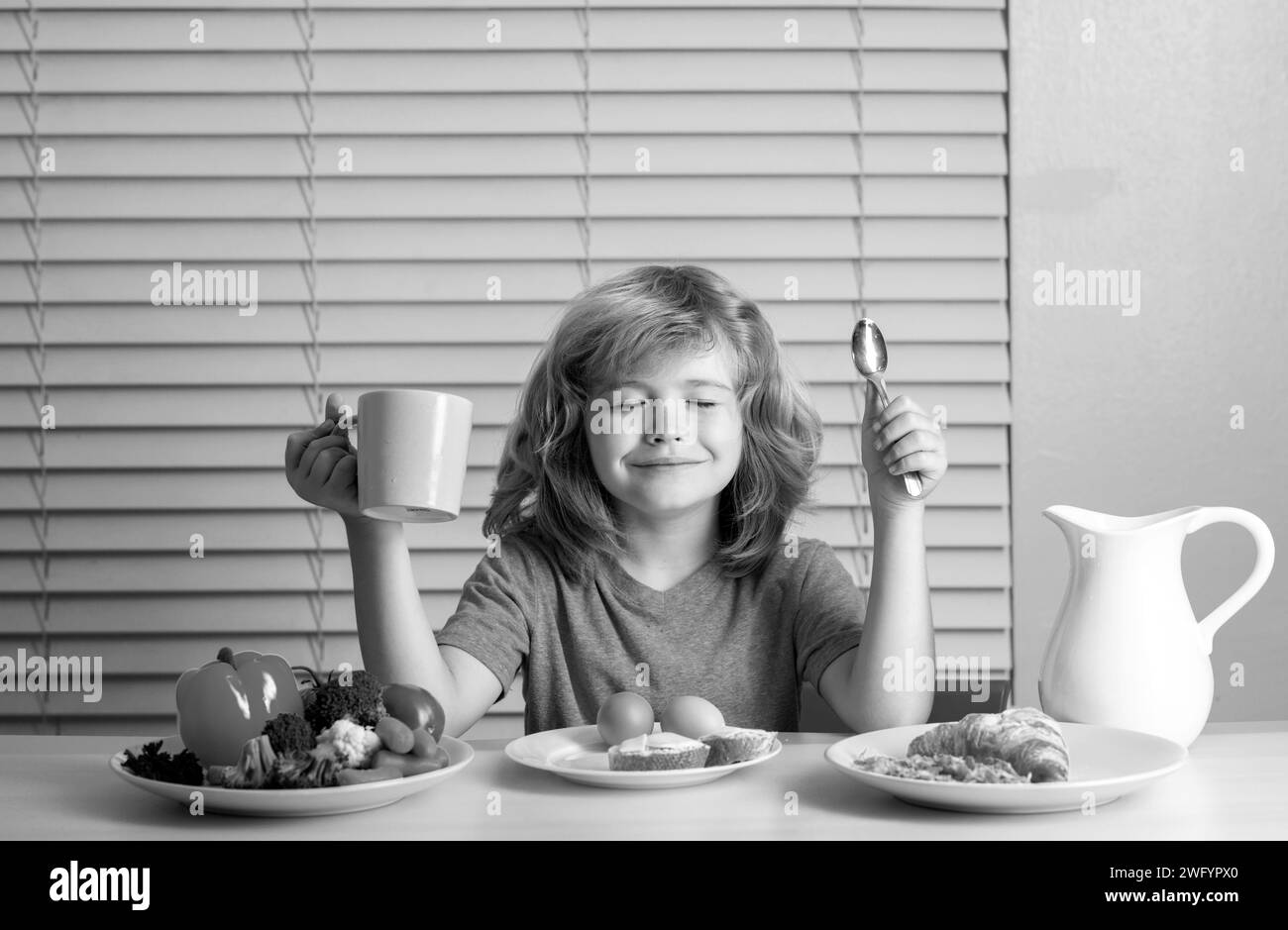 Petit-déjeuner scolaire avant l'école. Portrait de l'enfant s'asseoir au bureau à la cuisine maison ont délicieux petit déjeuner nutritif savoureux Banque D'Images