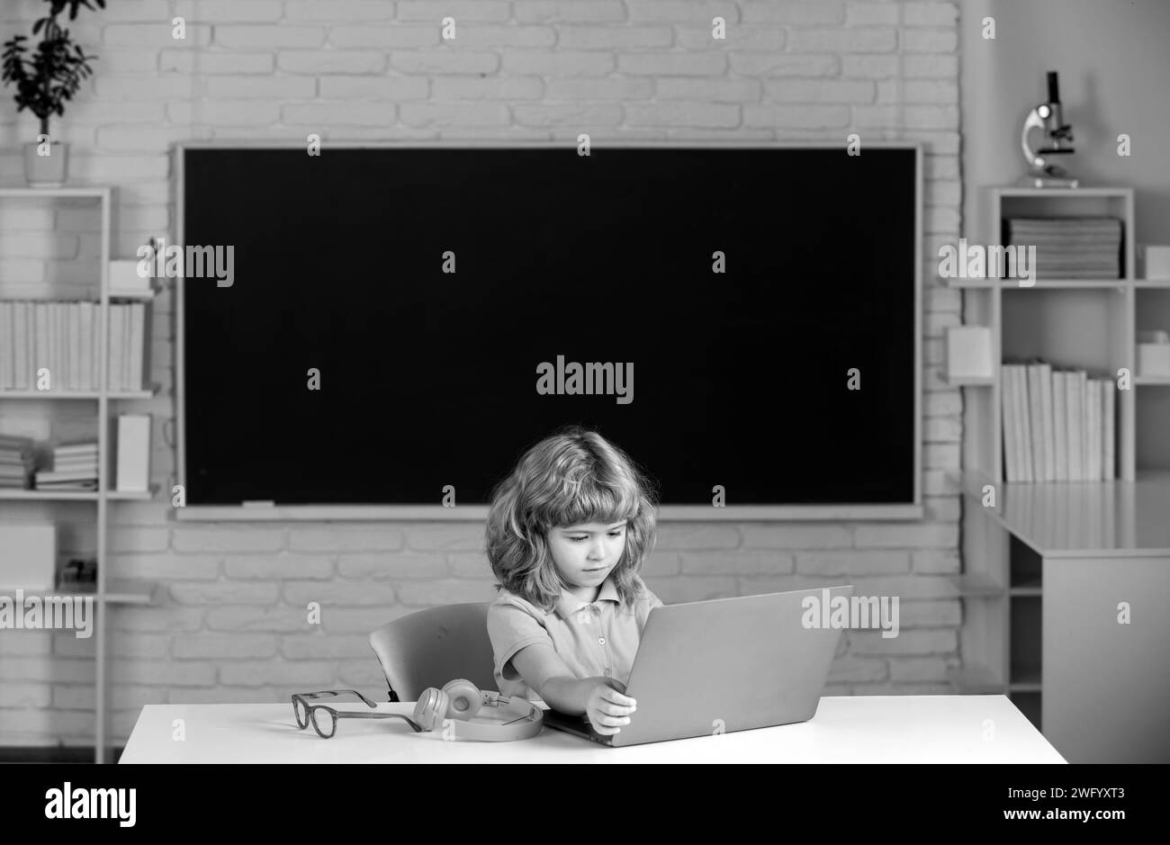 Enfant garçon utilisant un ordinateur portable à l'école Banque D'Images