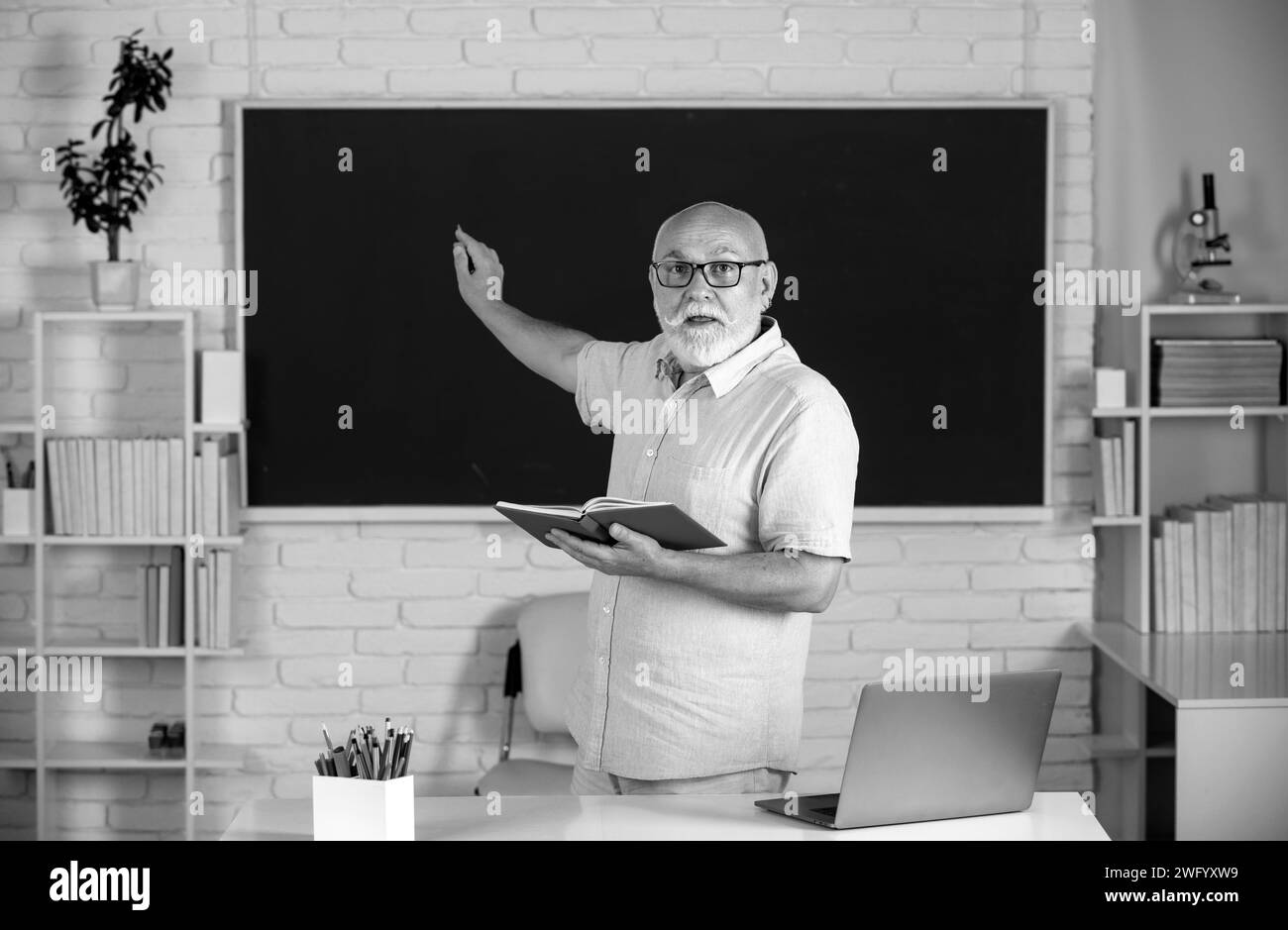 Journée des enseignants. Portrait d'un professeur mature ou d'un professeur tuteur travaillant à table au collège ou au lycée Banque D'Images Journée des enseignants. Portrait d'un professeur mature ou d'un professeur tuteur travaillant à table au collège ou au lycée Banque D'Images