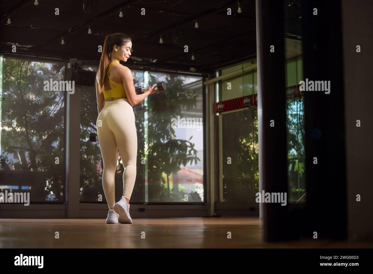 Fitness femme asiatique faisant de l'exercice et soulevant des haltères au gymnase sportif. Banque D'Images