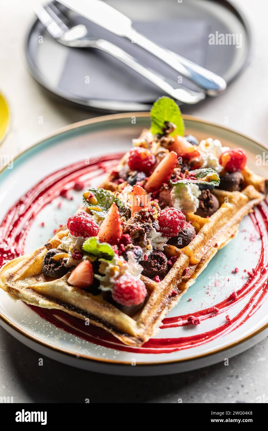 Gaufres maison avec fraises, framboises et crème fouettée. Banque D'Images