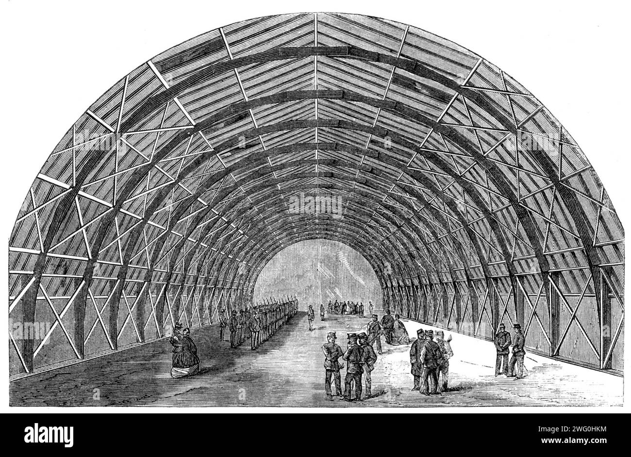 Graissage volontaire à Birkenhead pour le 1st Cheshire Volunteer Engineers, 1862. « L'idée du bâtiment est tirée d'un hangar conçu par le capitaine Fowke, R.E. (le concepteur du nouveau bâtiment de l'exposition de 1862)... la longueur du bâtiment est de 200 pieds, la largeur de 52 pieds, et la hauteur de 28 pieds 6 pouces. Lorsqu'il est éclairé, l'intérieur du bâtiment a un effet très fin - plus de 200 jets de gaz jetant une lumière forte et efficace partout. Un orchestre capable d’accueillir 150 interprètes a été érigé et les principes acoustiques sont admirables. Le coût du hangar sera d'environ Banque D'Images
