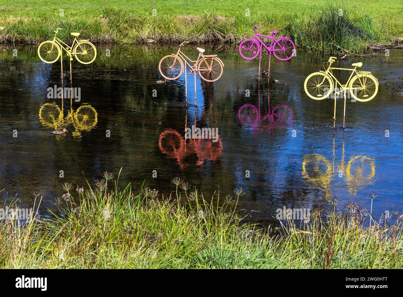 Installation de vélos colorés dans l'eau par une journée d'été ensoleillée Banque D'Images