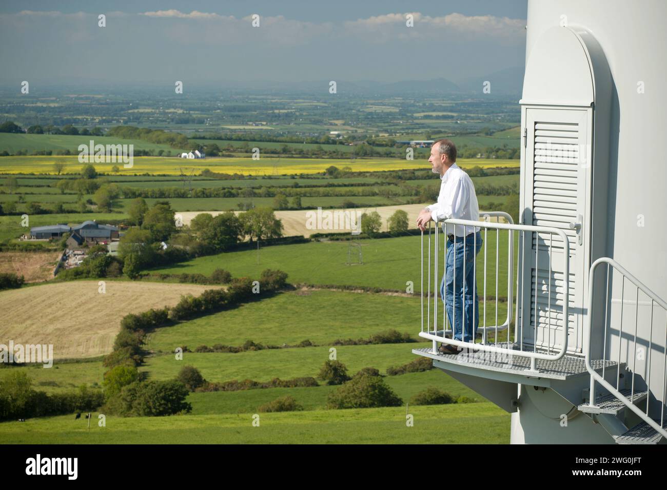 Un homme examine la vue sur Collon, Irlande depuis les marches d'une éolienne. Banque D'Images