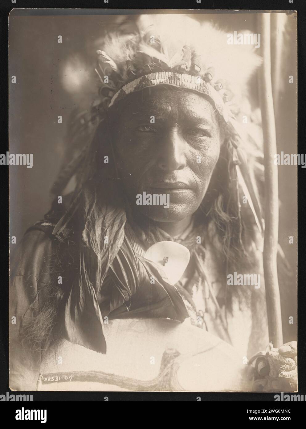 Big Road (Chanckin Tan-Ka), 1907. La photographie montre le portrait tête et épaules de Big Road, portant une coiffe, tenant le bâton et le bouclier, face à l'avant. Banque D'Images