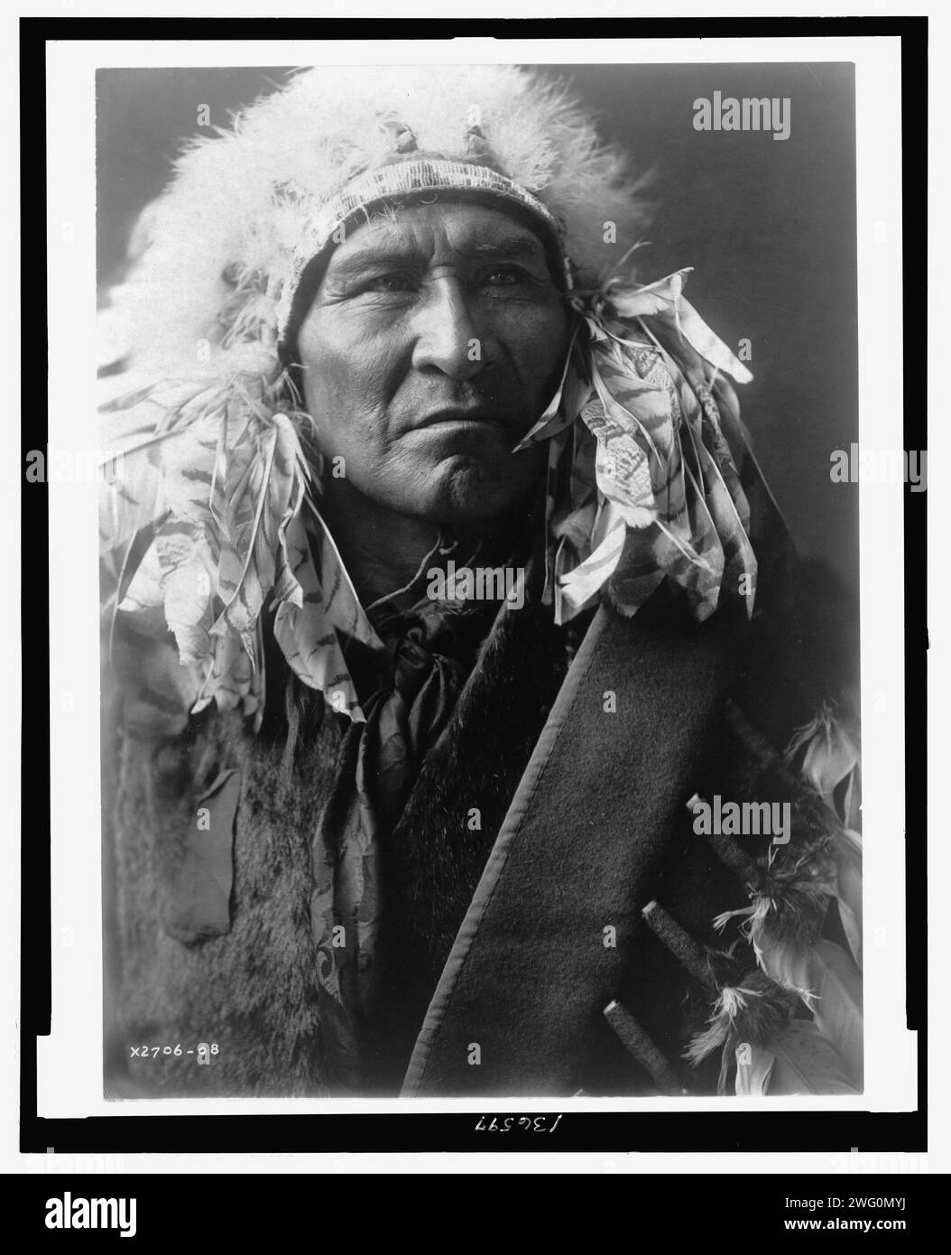 Pain, Apsaroke, c1908. La photographie montre Bread, un Indien Apsaroke, portrait de la tête et des épaules, face à l'avant, portant une coiffe. Banque D'Images