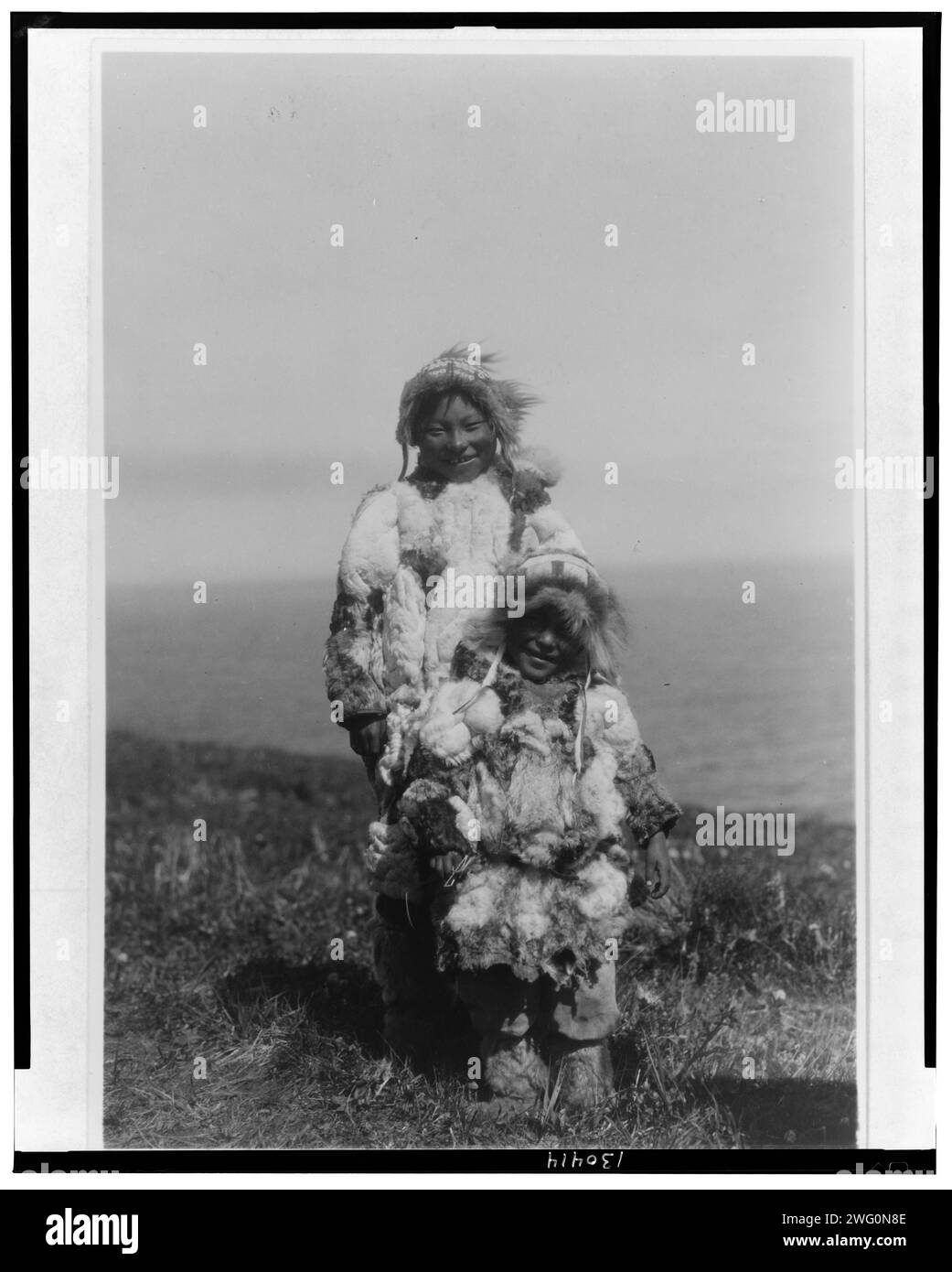 Parkas en peau de canard, Nunivak, c1929. Eskimo adulte et enfant portant des parkas en peau de canard. Banque D'Images
