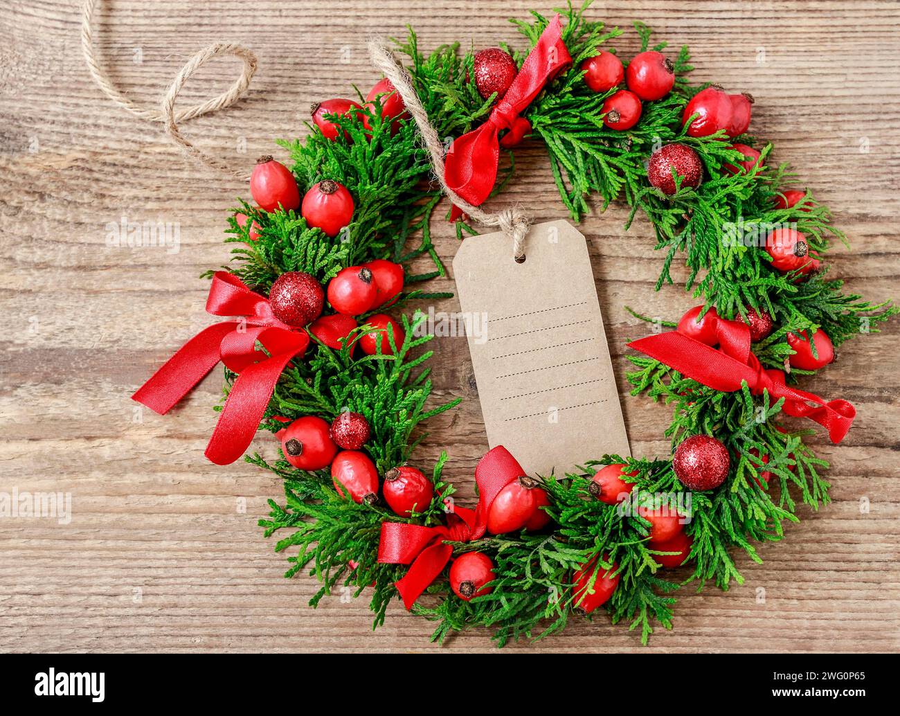Couronne de porte de Noël traditionnel avec des brindilles et thuja vert rose fruits sauvages. Décoration de fête Banque D'Images