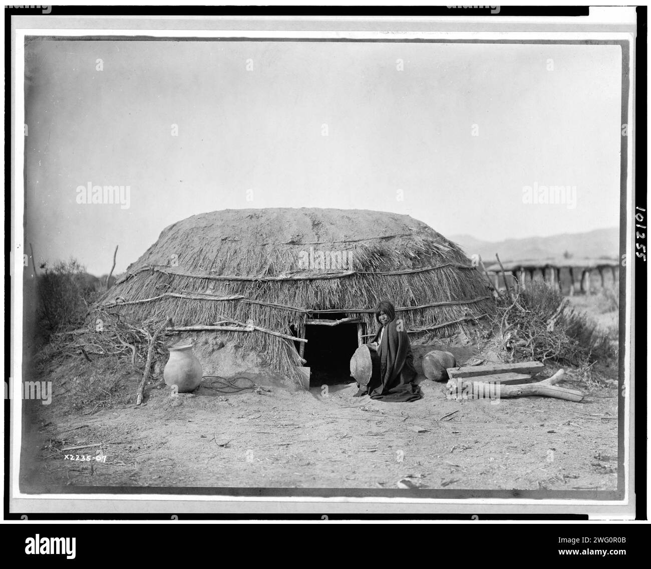 Pima ki (maison primitive), Pima, Arizona], 1907, c1907. Montre la structure faite de flèche et de terre, et la femme assise près de la porte. Banque D'Images