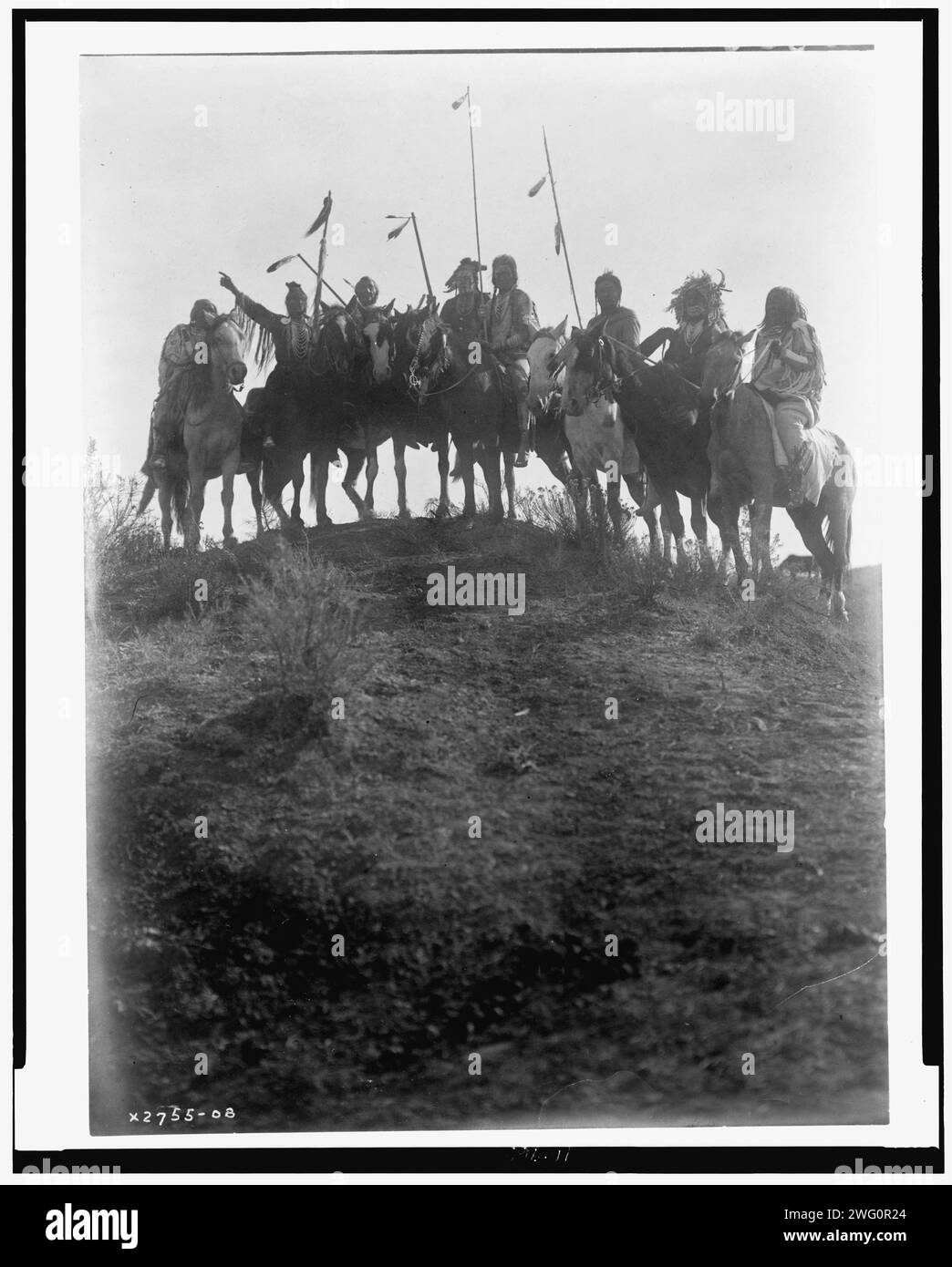 Au sommet de la colline, c1908. Huit Indiens Crow à cheval, silhouettés au sommet de la colline, l'homme deuxième à partir de la gauche pointe, Montana. Banque D'Images Au sommet de la colline, c1908. Huit Indiens Crow à cheval, silhouettés au sommet de la colline, l'homme deuxième à partir de la gauche pointe, Montana. Banque D'Images