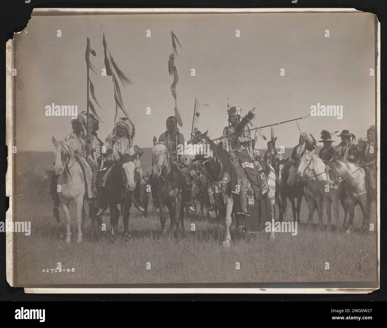 Victoire, 1908. La photographie montre plusieurs Indiens Crow, dont Plenty coups, Wet, Bull Don't Fall Down et Spotted Jack Rabbit portant des vêtements et coiffes traditionnels alors qu'ils transportaient des bâtons à cheval. Banque D'Images Victoire, 1908. La photographie montre plusieurs Indiens Crow, dont Plenty coups, Wet, Bull Don't Fall Down et Spotted Jack Rabbit portant des vêtements et coiffes traditionnels alors qu'ils transportaient des bâtons à cheval. Banque D'Images
