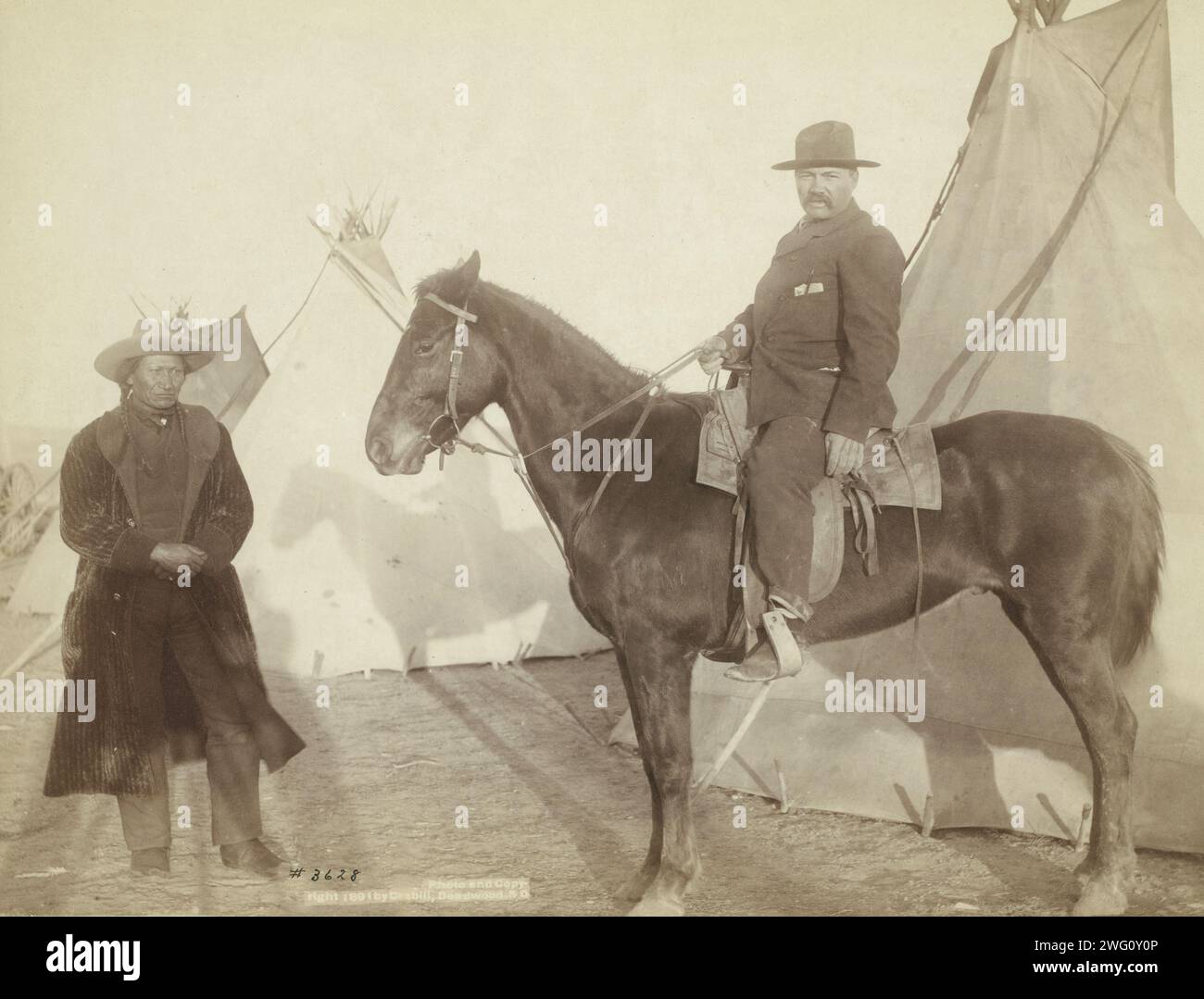 Maison du chef Rocky Bear, 1891. Rocky Bear, chef Oglala, debout à gauche d'un homme euro-américain à cheval ; trois tipis en arrière-plan--probablement sur ou près de la réserve de Pine Ridge. Banque D'Images